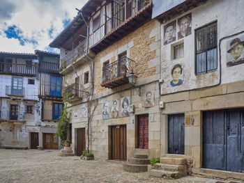 Exterior of old building by street against sky