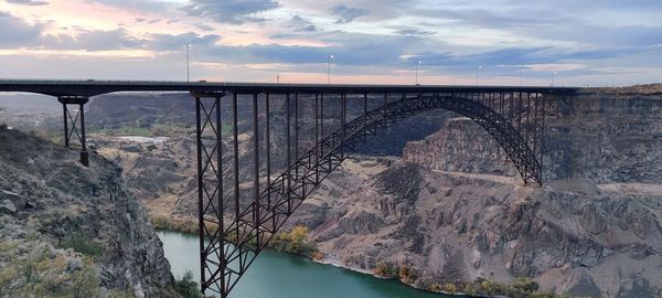 Arch bridge over river against sky