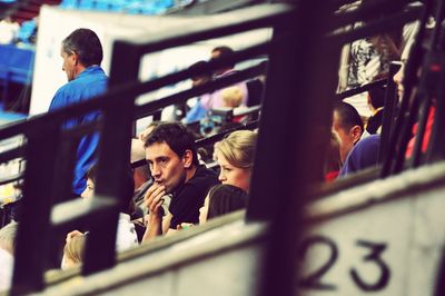 Portrait of people sitting on railing
