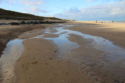 Skies reflected in sea water pools norfolk east anglia uk