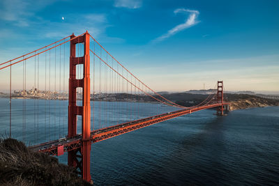 View of suspension bridge against cloudy sky