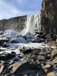 Scenic view of waterfall against sky during winter