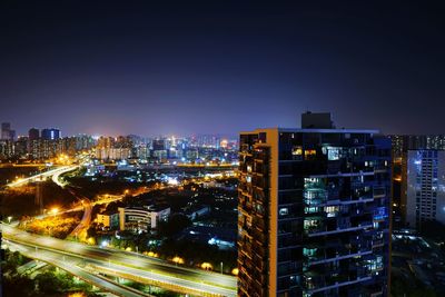 Illuminated cityscape against sky at night