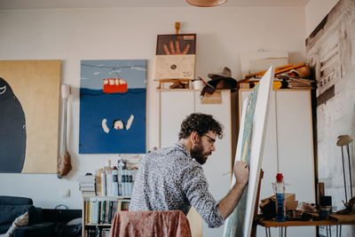 Man looking at camera while standing on table at home