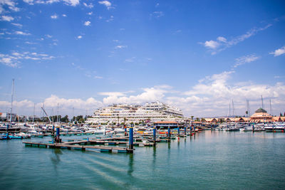 Boats moored in harbor against buildings in city