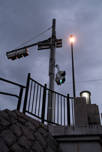 Low angle view of illuminated street light against sky at dusk