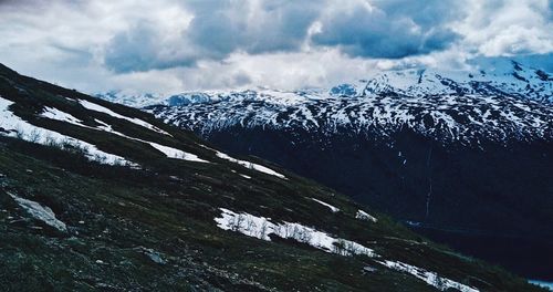 Scenic view of snowcapped mountain against cloudy sky