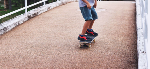 Low section of woman walking on skateboard