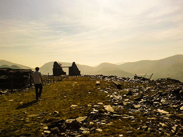 mountain, full length, built structure, house, one person, sky, architecture, sunset, outdoors, walking, building exterior, rear view, adults only, standing, silhouette, landscape, one man only, adult, nature, people, only men, beauty in nature, day