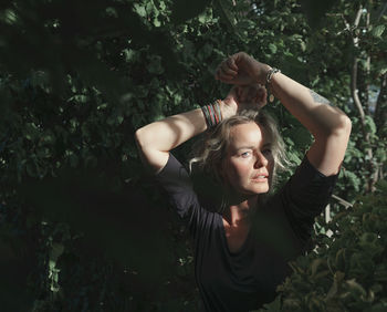 Portrait of woman standing by plants