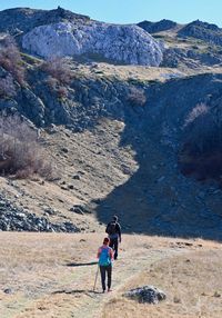 Rear view of friends walking on mountain