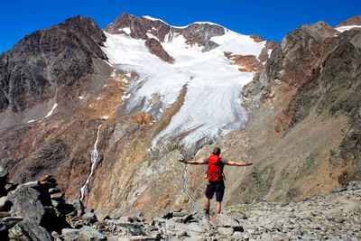 Man standing on rock against sky