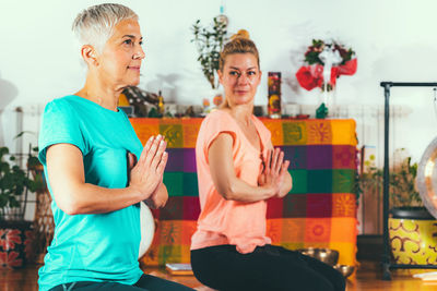 Mother and daughter practicing yoga at spa
