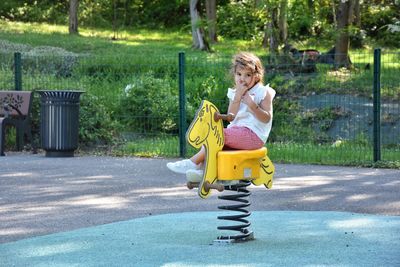 Portrait of girl playing on spring ride at park