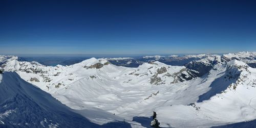 Scenic view of snowcapped mountains against clear blue sky