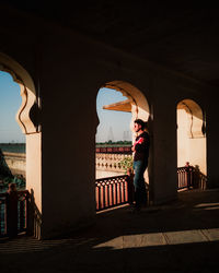 Woman standing by historic building