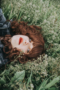 High angle portrait of woman lying on plants