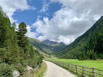 Road amidst green landscape against sky