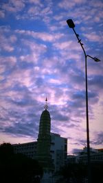 Buildings against cloudy sky at sunset