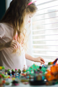 Girl playing with toys by window at home