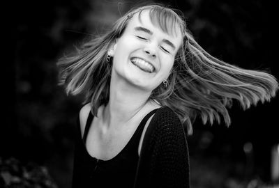 Close-up of smiling teenage girl tossing hair