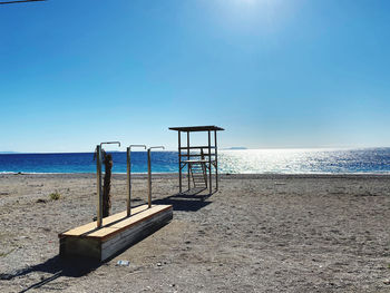 Lifeguard hut on beach against clear blue sky