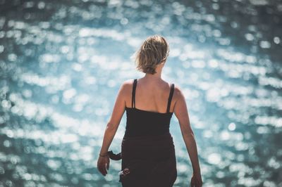 Rear view of woman standing against sea