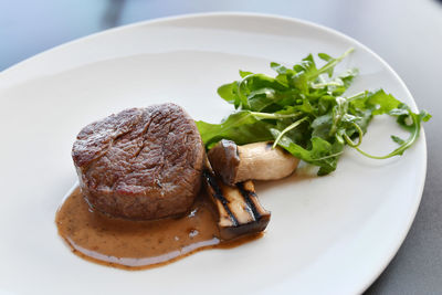 High angle view of steak with mushroom and herbs served on table