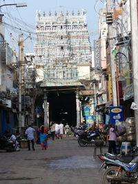 People on street amidst buildings in city