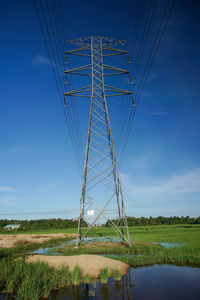 Electricity pylon on field against sky