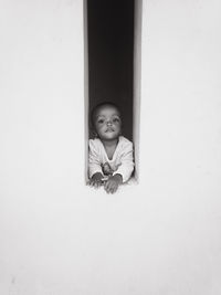 Portrait of a child standing against wall