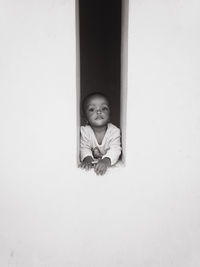 Portrait of young woman standing against wall