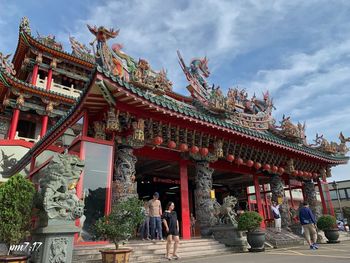 People outside temple against building