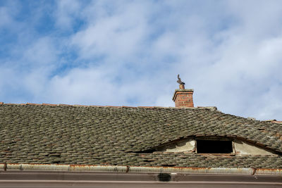 Romanian ceramic shingle roof with brick chimney and old television antenna