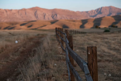 Wooden fence on landscape against mountains