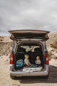 Kids having a picnic in the trunk of their car during vacation holiday