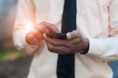 Midsection of man using mobile phone