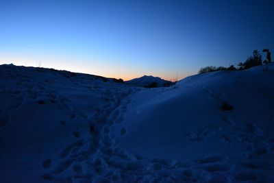 Scenic view of snow covered mountains against clear blue sky
