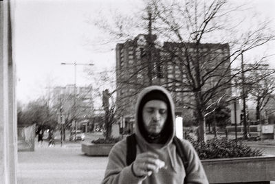 Portrait of man with umbrella on street in city