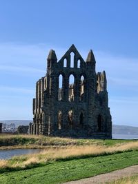 Old ruin building on field against sky