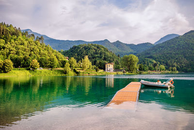 Scenic view of lake by mountains against sky