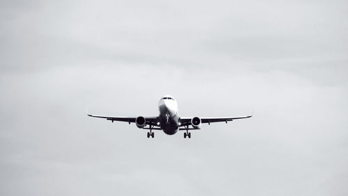 Low angle view of airplane flying against sky