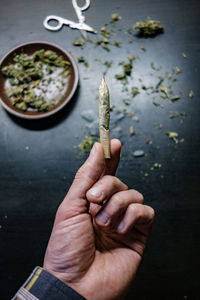 Cropped hands of man holding marijuana joint