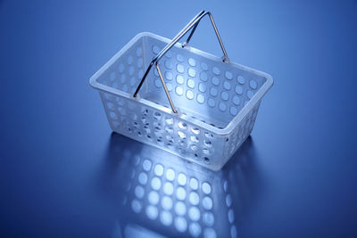 Close-up of shopping basket on blue table
