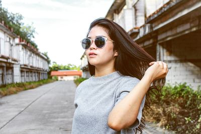 Portrait of young woman wearing sunglasses standing outdoors