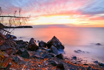 Scenic view of sea against dramatic sky during sunset