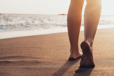 Low section of woman standing on beach