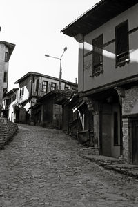 Empty alley amidst houses against buildings in city