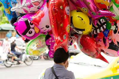 Close-up of woman holding colorful balloon