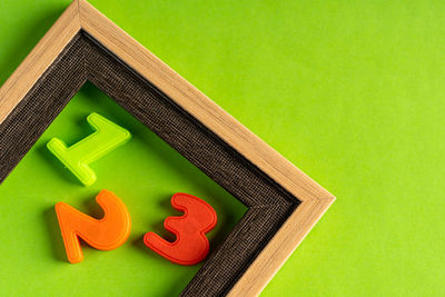 Close-up of toys on table against green background